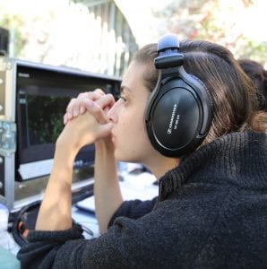 A woman wearing headphones looking at a screen