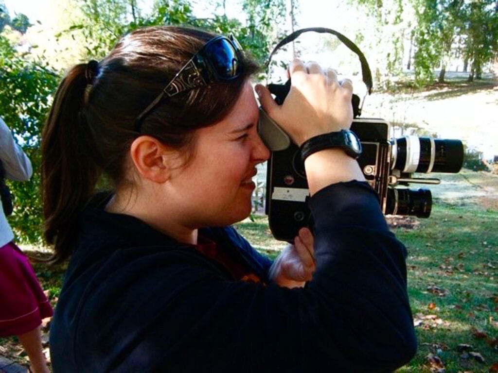 Side profile of Amy Taylor holding a camera up to her eye.