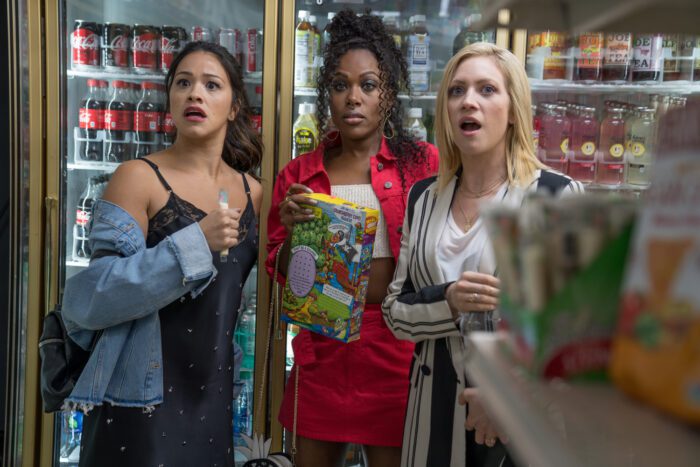 Jenny, Erin, and Blaire stand together in a convenience store, looking shocked at something. 