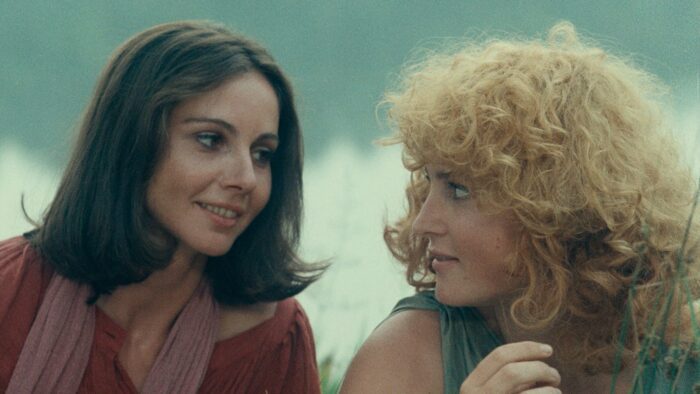 Suzanne and Pauline look at each other, smiling. 